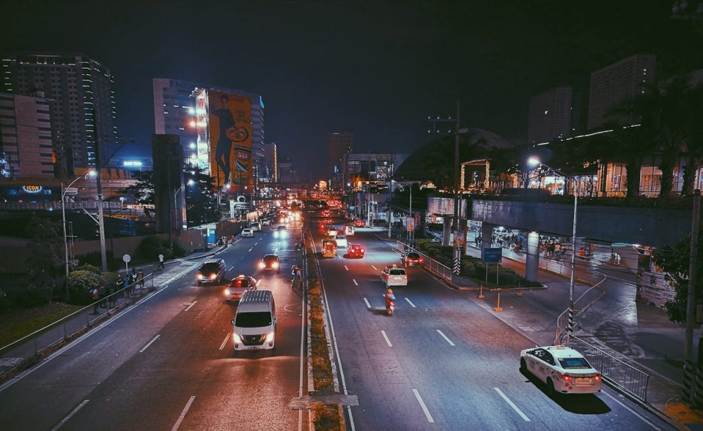Busy expressway with vibrant city life and illuminated skyscrapers at night.