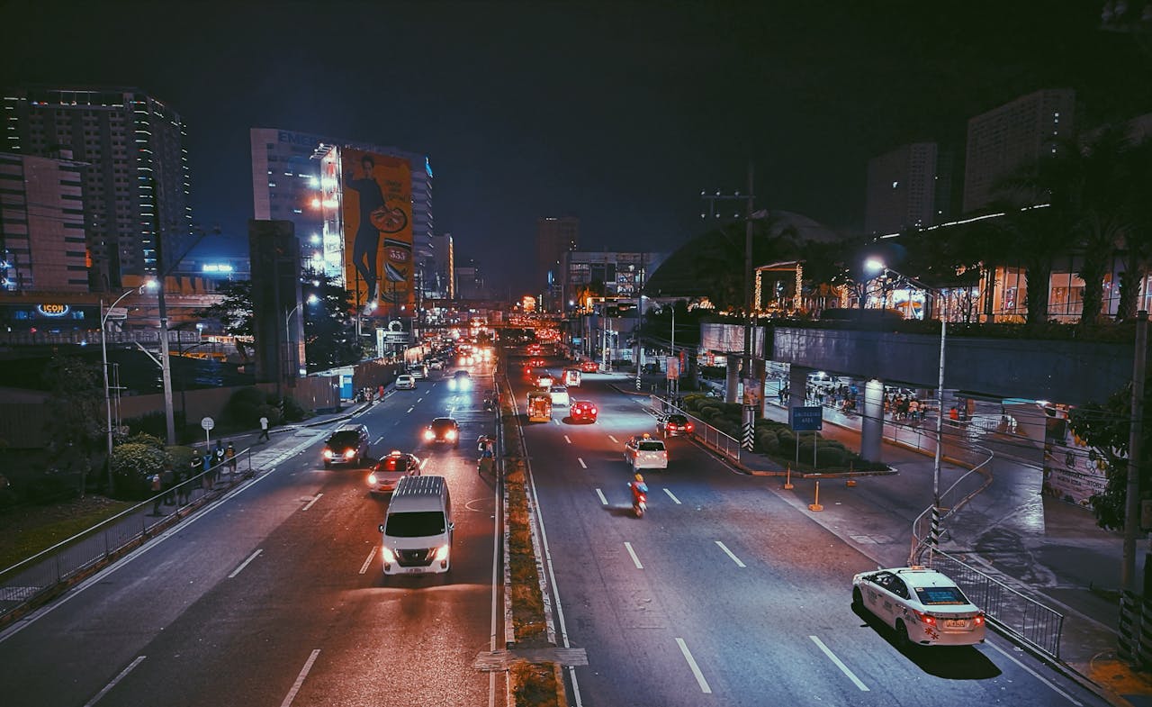 Busy expressway with vibrant city life and illuminated skyscrapers at night.